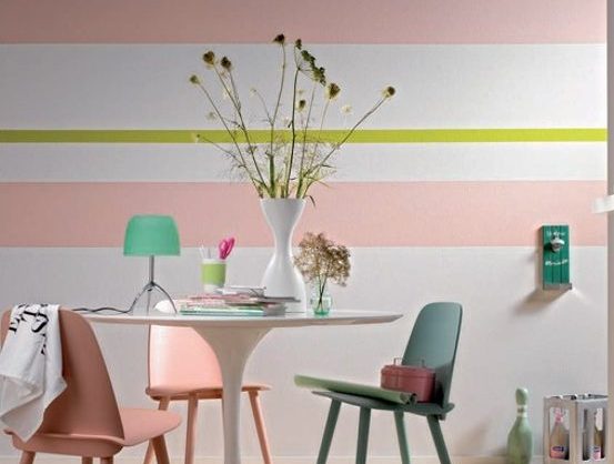 Stühle um einen Tisch, dahinter eine bunt gestrichene Wand.