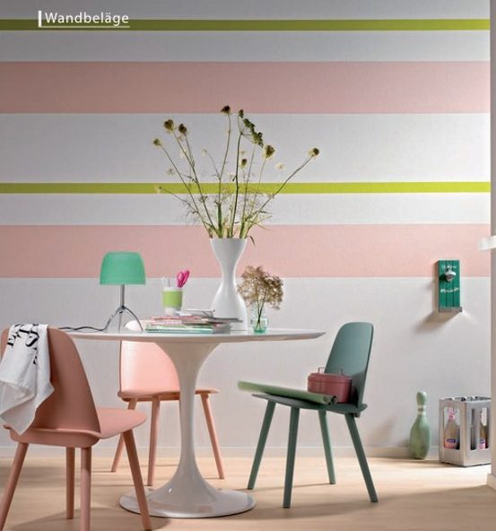 Stühle um einen Tisch, dahinter eine bunt gestrichene Wand.