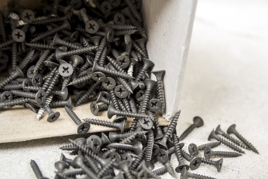 Schrauben, die aus einer kleinen Schachteln fallen