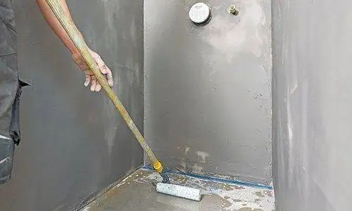 Grundierrolle grundiert den Boden im Badezimmer.