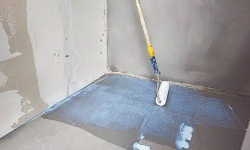 Imprägnierung des Badezimmerbodens mit einer Rolle.