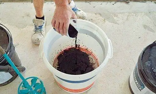 Mischen von Farbpigmenten und Wasser für Badezimmer Betonoptik.