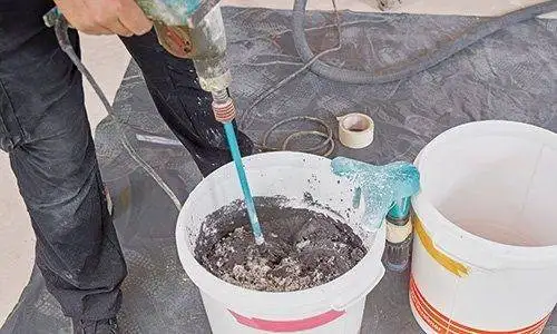 Erneutes Mischen der Spachtelmasse im Eimer.