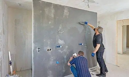 Zwei Männer: Mit Traufeln wird die eingefärbte Spachtelmasse weiter aufgezogen.