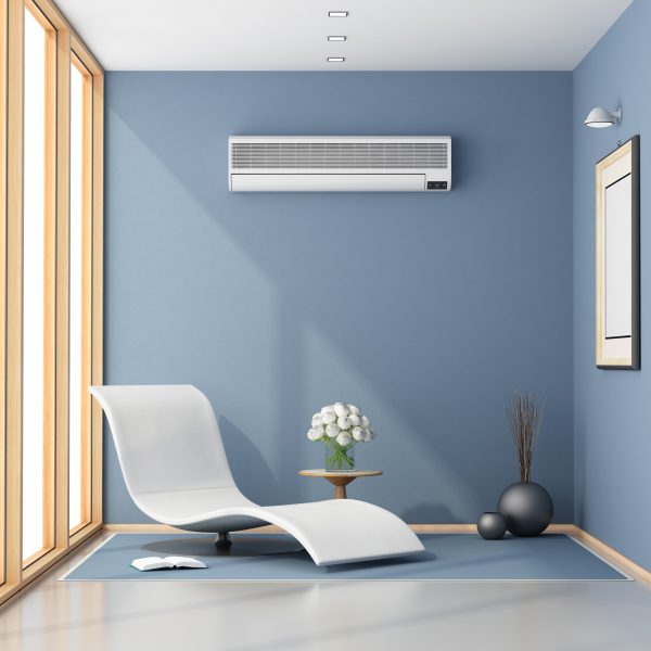 Raum mit blauen Wänden und einer großen Fensterfront und Sitzmöbeln. An der Wand befindet sich eine Klimaanlage.