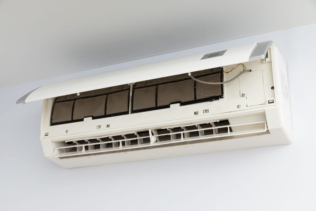 Energieeffizient Kühlen – Moderne Klimatisierungstipps für heiße Sommer 2 Offene Klimaanlage an der Wand mit schmutzigem Filter