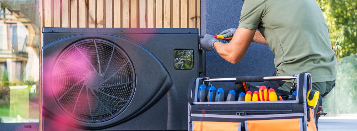 KfW startet Heizungsförderung für klimafreundliche Heizungen 4 Wärmepumpen Monteur an Wärmepumpe außen