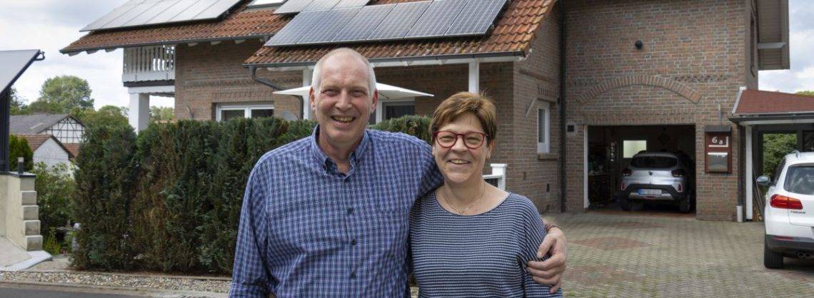 Daikin_Scholl Ehepaar vor Wohnhaus mit Solarpanelen auf dem Dach.