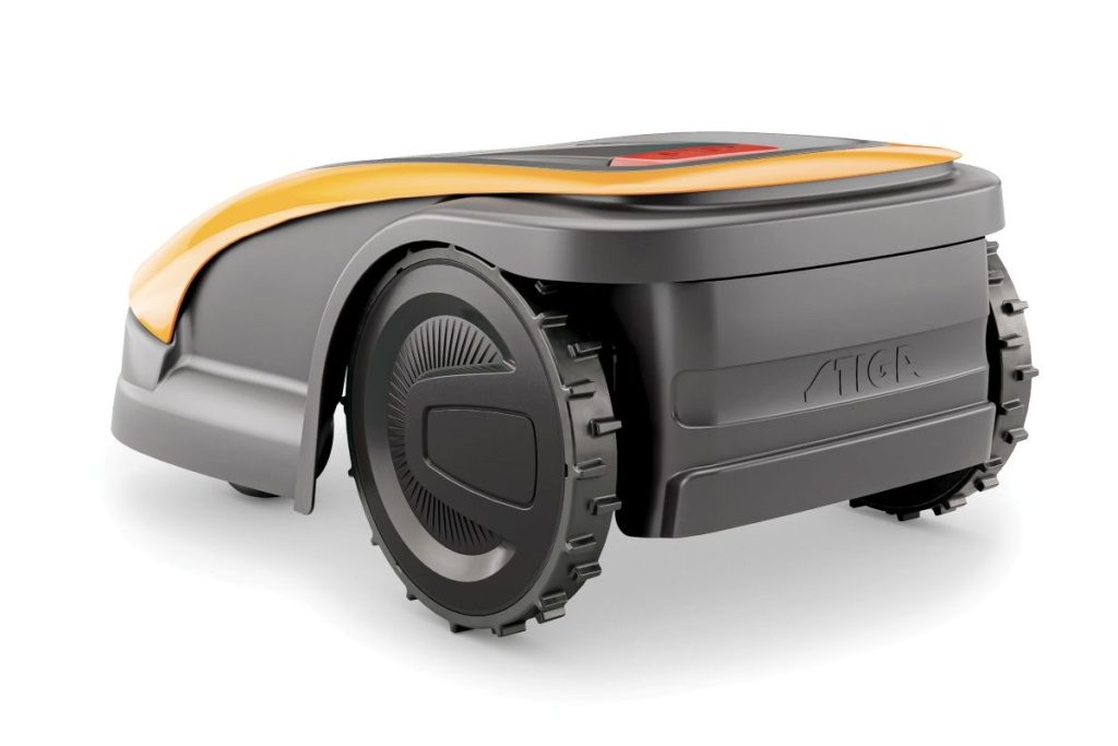 Stiga Rasenroboter von hinten seitlich: Stiga Rasenroboter dunkel: Detailansicht des Rasenroboters. Der Roboter ist anthrazit und hat einen roten Schalter. Orangefarbig abgesetzte Elemente am Gehäuse. Zu sehen sind die beiden größeren Hinterräder.