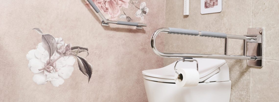 Barrierefreie Toilettenanlage: Weißes Wand-WC mit integriertem Toilettenpapierhalter am seitlichen, hochklappbaren Stützgriff. An der angrenzenden Wand befindet sich ein winkelbarer Haltegriff vor einer Tapete mit großflächigen, altrosa Pfingstrosen-Illustrationen. Die Fliesen sind in hellem Beige gehalten.