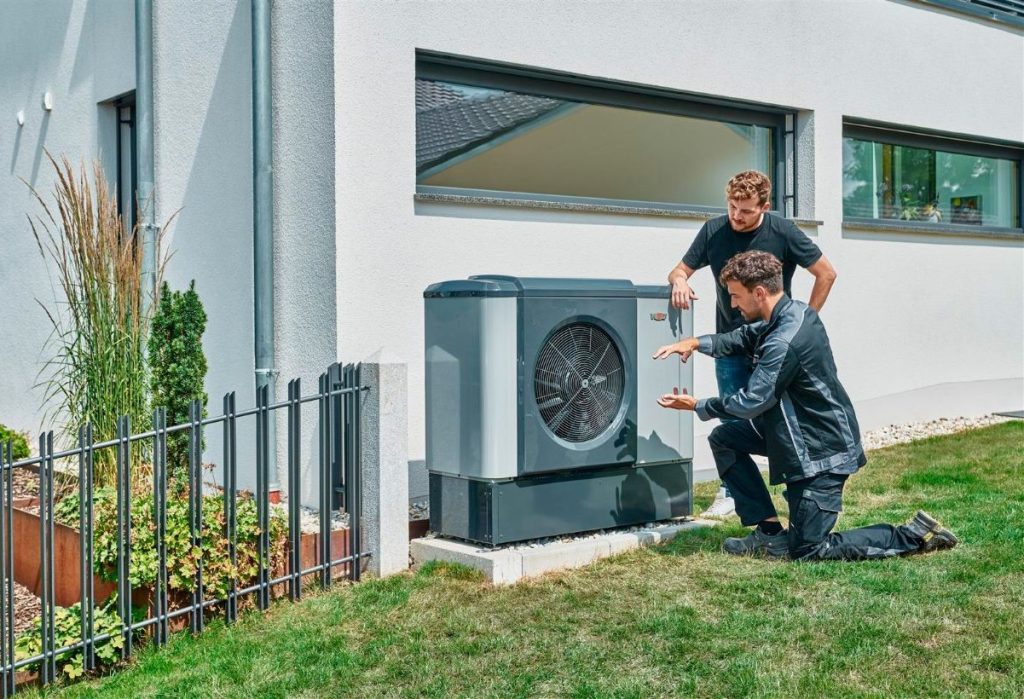 Wolf Wärmepumpe steht stabil auf Fundament Techniker erklärt Funktionsweise