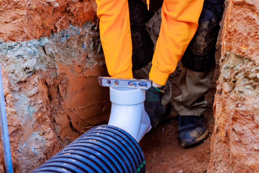 Arbeiter checkt einen Kanal für die Sanierung