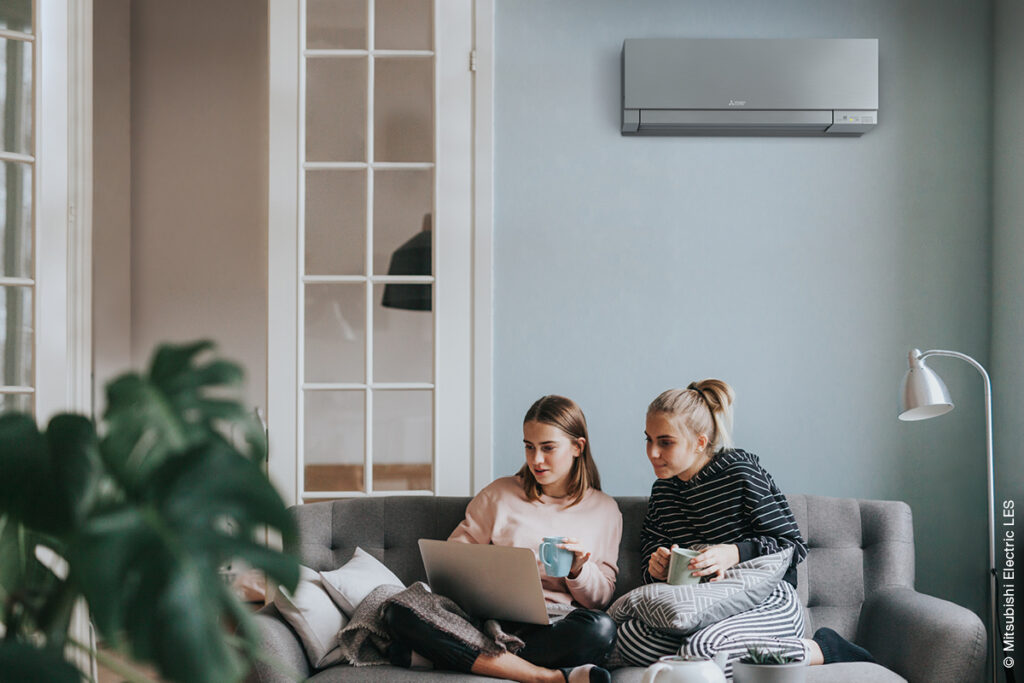 Mitsubishi zwei Frauen in modernem Wohnzimmer mit Wärmepumpe